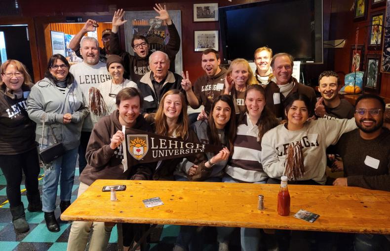 A group of Lehigh football fans gather for a photo in a San Francisco bar