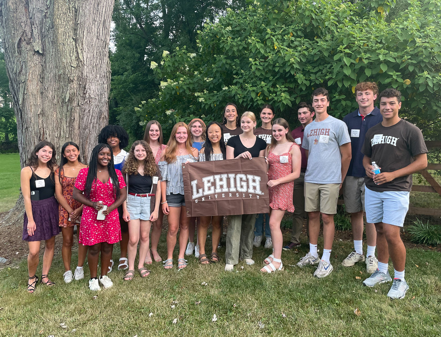 Incoming students holding a Lehigh banner and smiling at their local Sendoff location