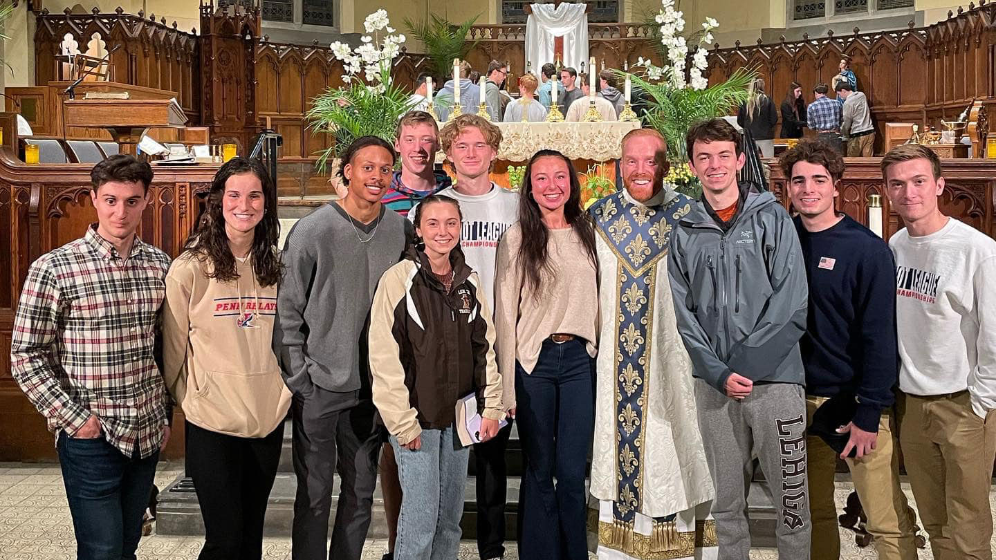Father Mark Searles, Lehigh’s Catholic chaplain poses for a group photo with Lehigh students.
