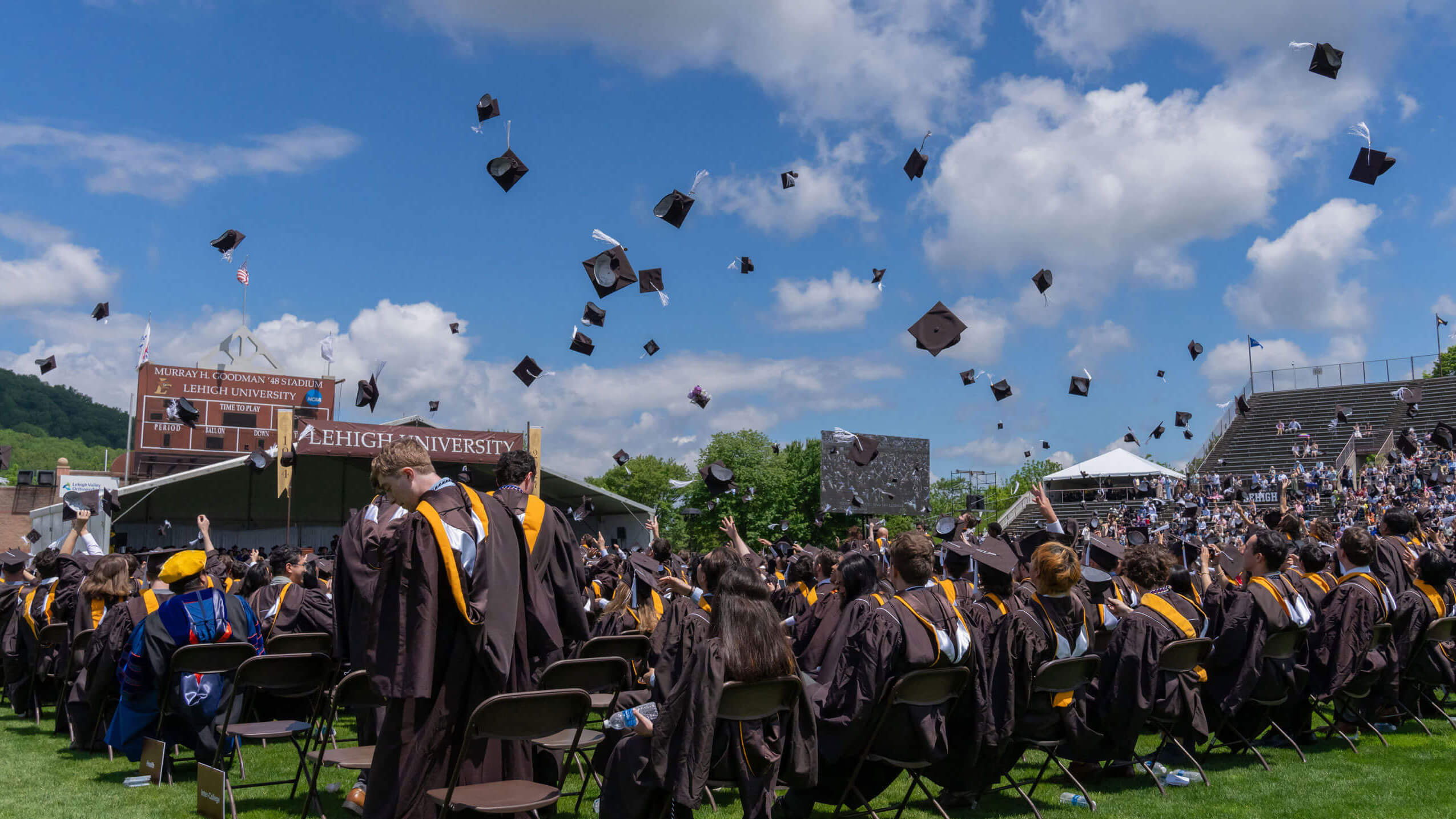 Graduates tossing their caps into the air on a sunny commencement day.