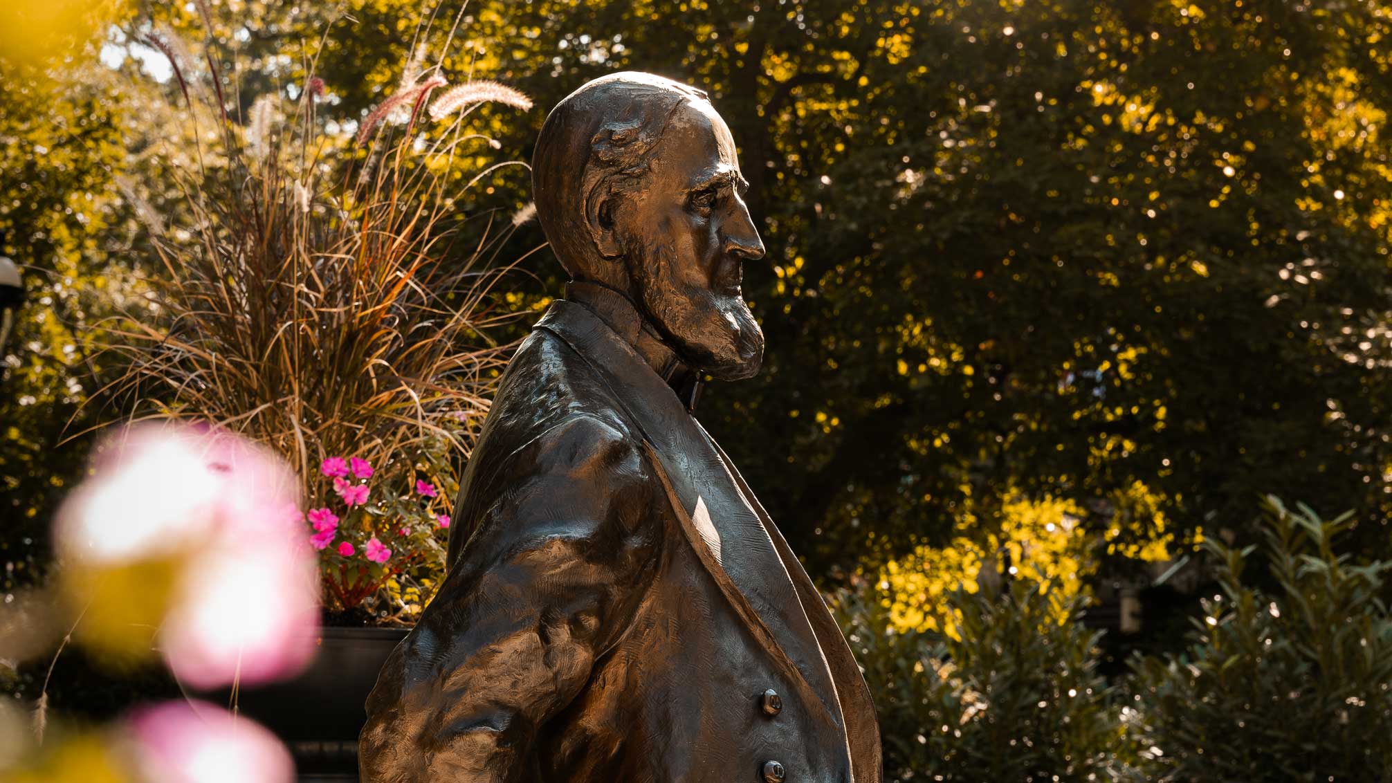 A profile of the statue of Asa Packer surrounded by golden sun beams