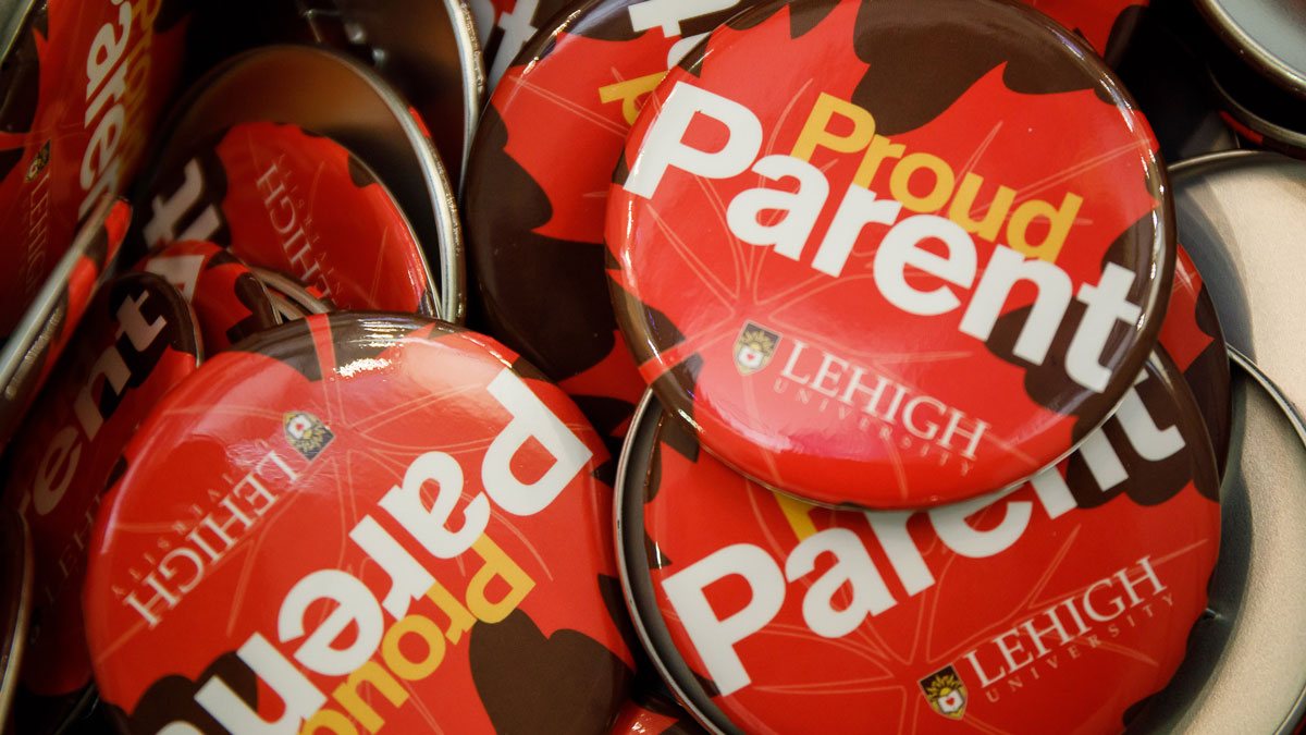 Collection of brown and orange "Proud Parent" round pins