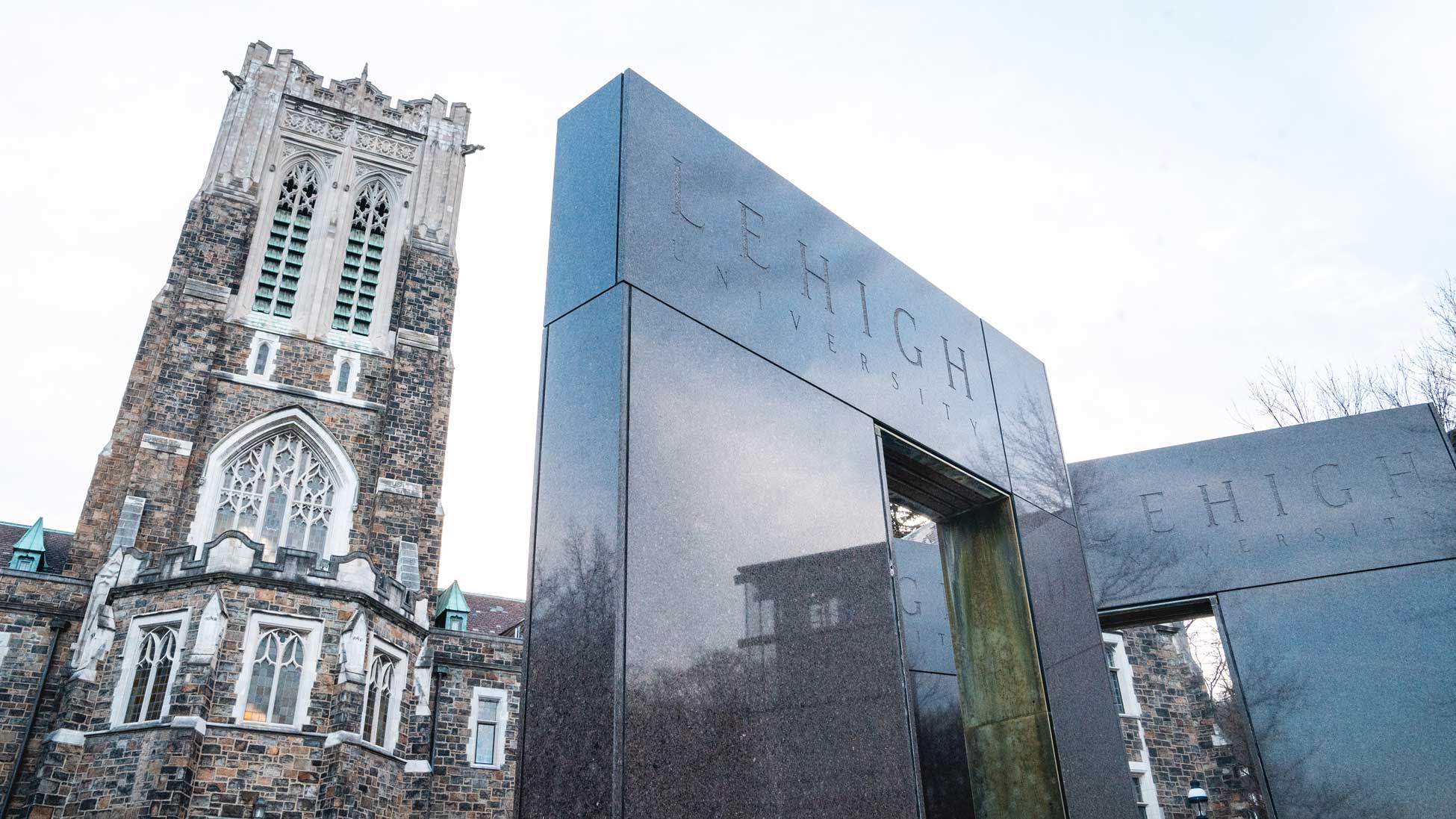 Alumni Memorial peaking over a fountain engraved with Lehigh University.