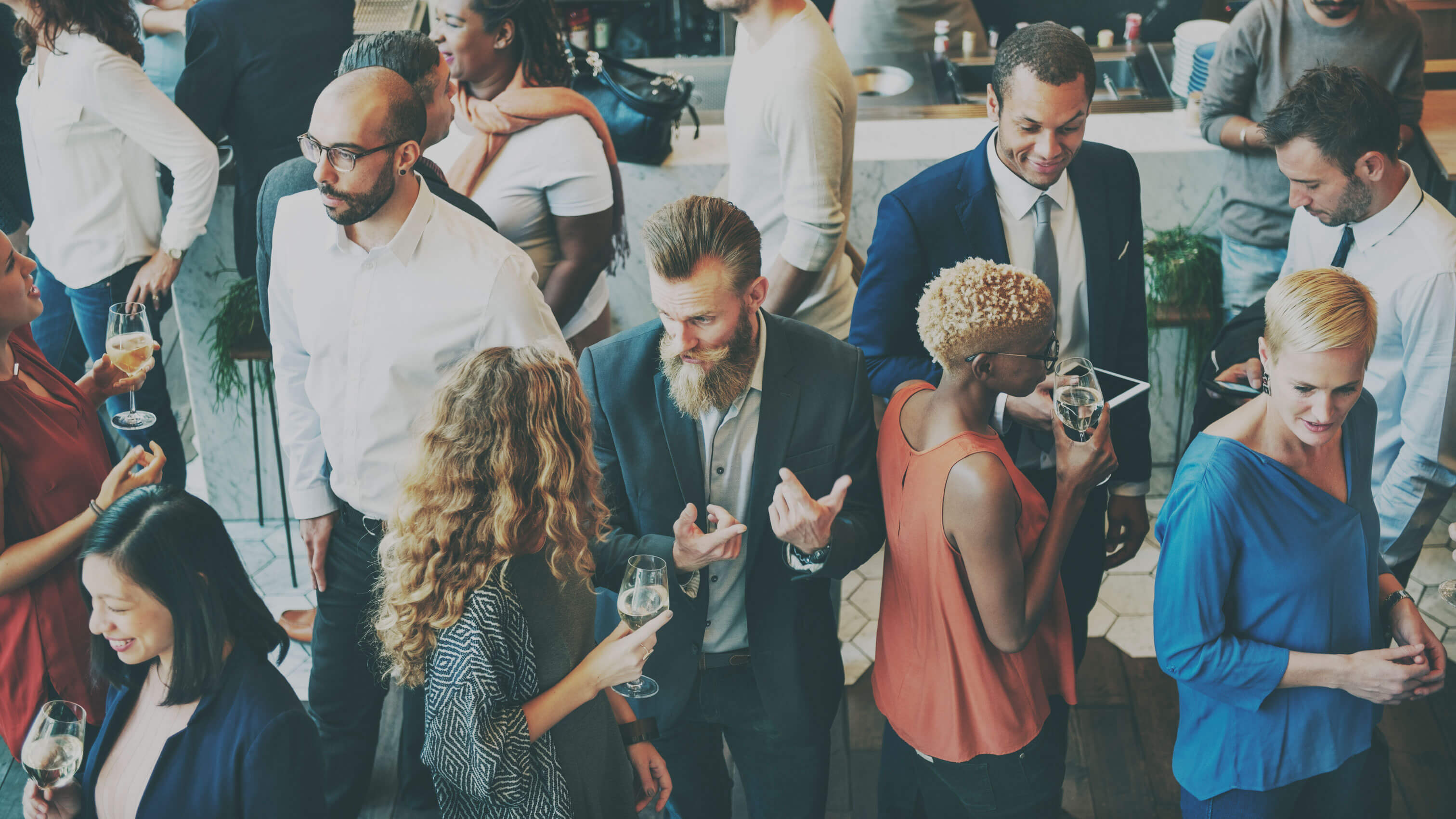 Various people dressed in business casual clothing while mingling in a crowd