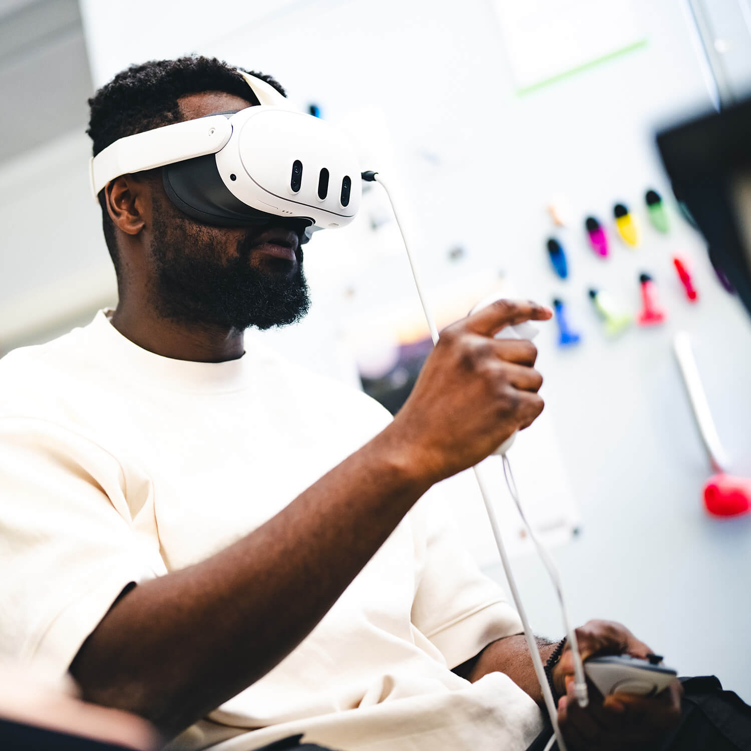 A man wears virtual reality head gear connected to a computer.