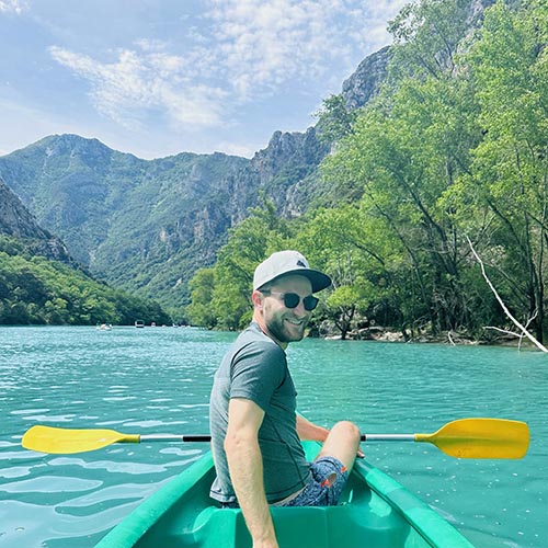 Dean Kroker turned around and smiling while sailing in a kayak.