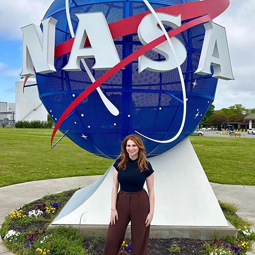 Rachel Sholder standing in front of a NASA globe statue.