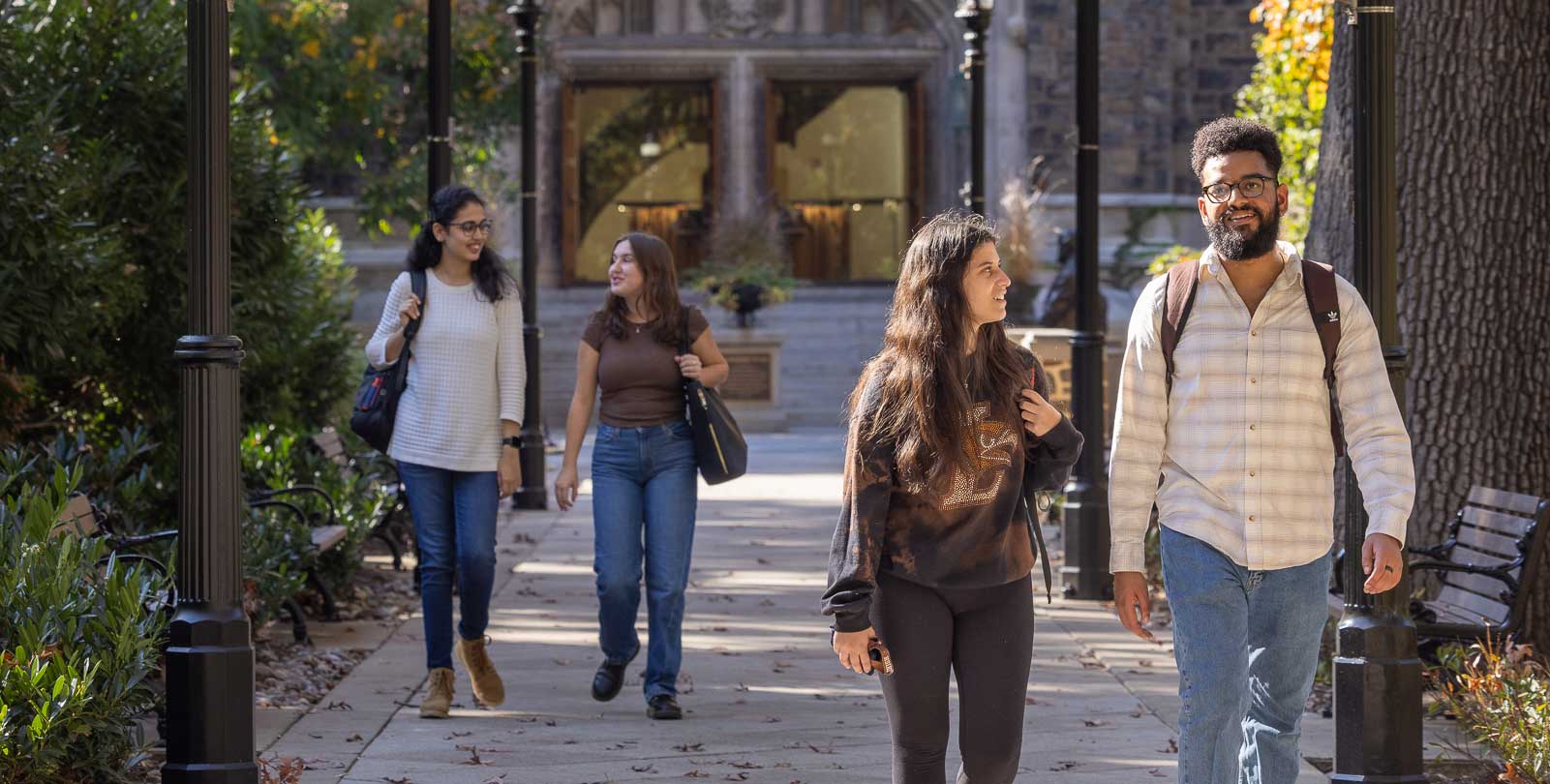 Students walking down Memorial walkway while conversing.
