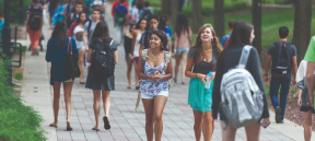 Students walking through Asa Packer campus wearing their backpacks.