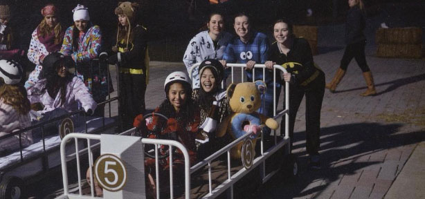 Students sitting in and ready to push a metal bed for bed races.