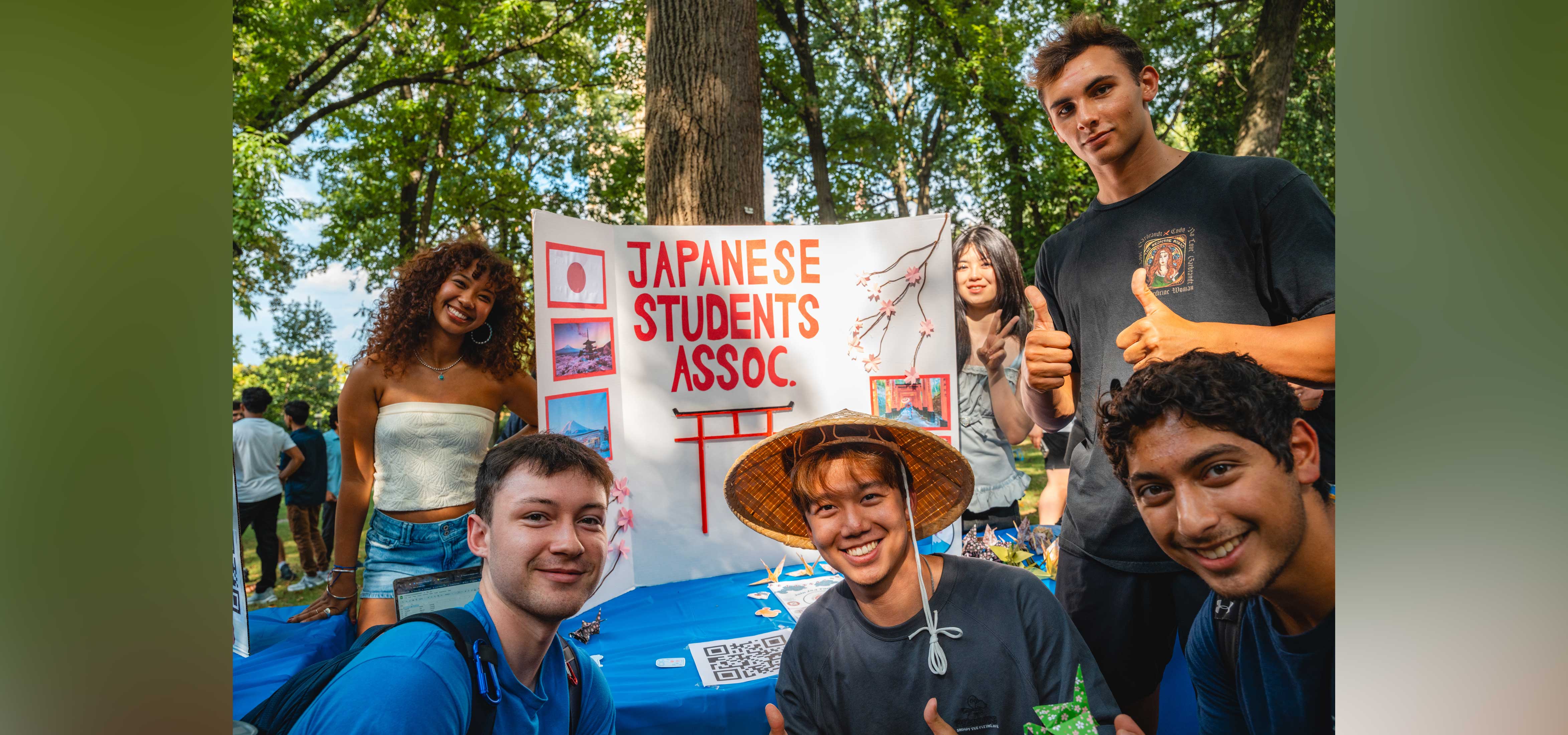 Members of the Japanese Students Association smile together around a sign up table.