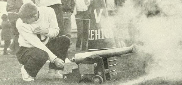 Vintage photo of a student wearing a white L crew neck, setting off a little canon.