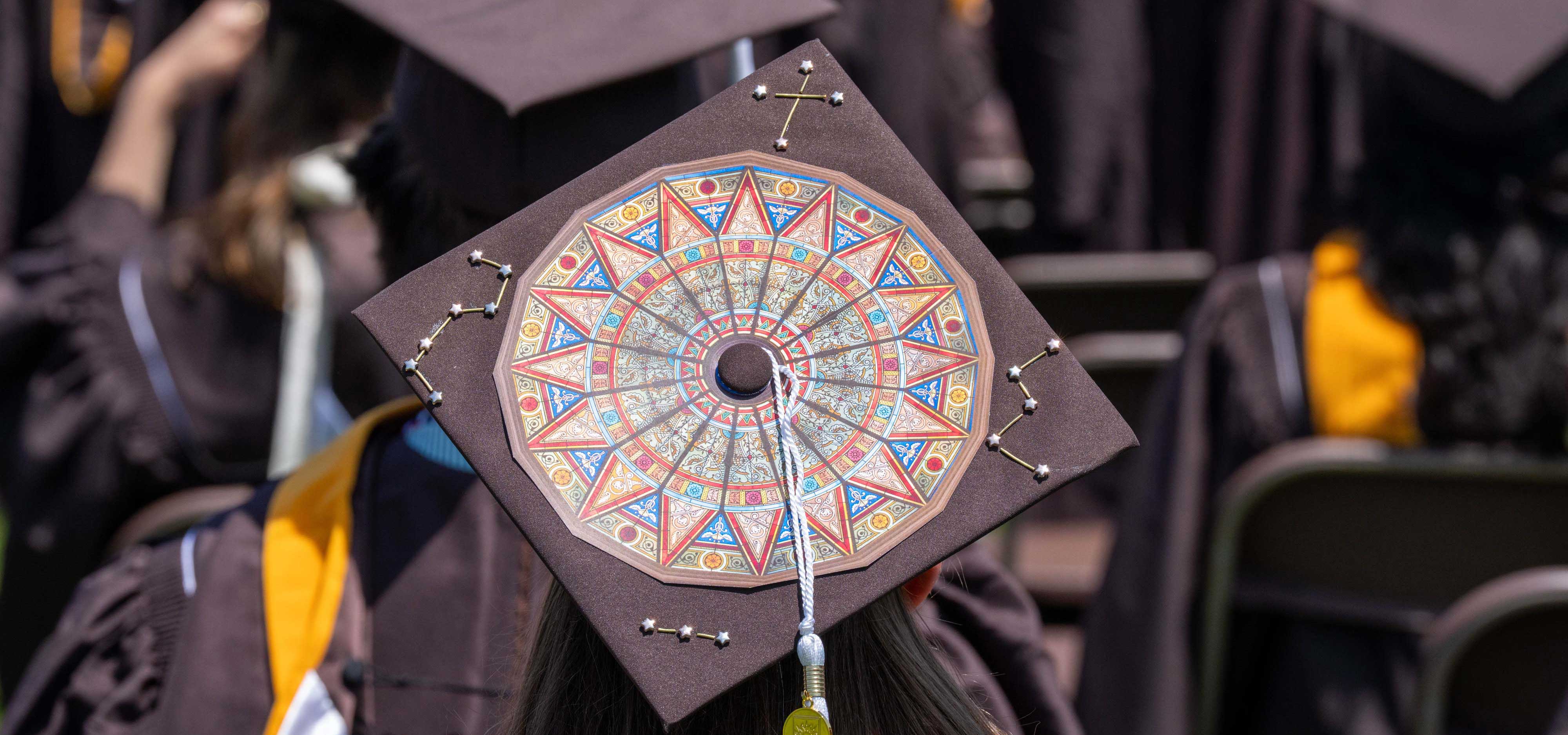 A students graduation cap among a sea of brown graduation regalia.