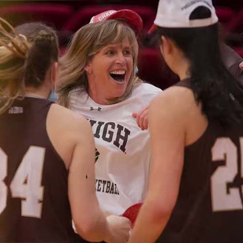 Sue Troyan cheers with her players on the court after a big win
