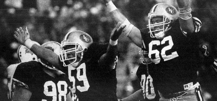 Black and white image of football players celebrating in their game day gear.