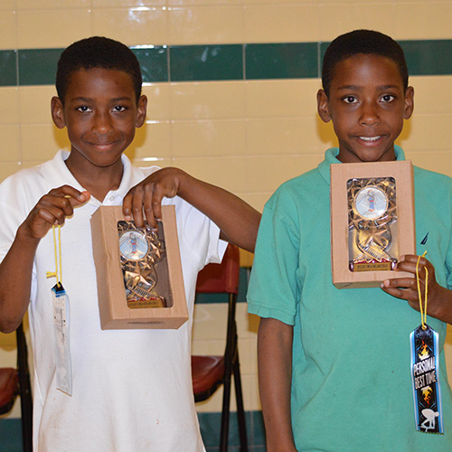 Aaron Williams and his twin brother hold gold ribbons.