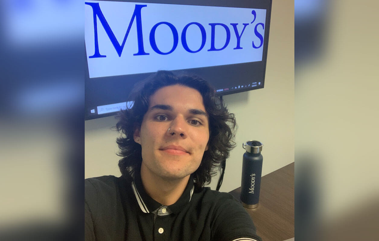 Ben Murphy taking a selfie in front of the Moody's logo