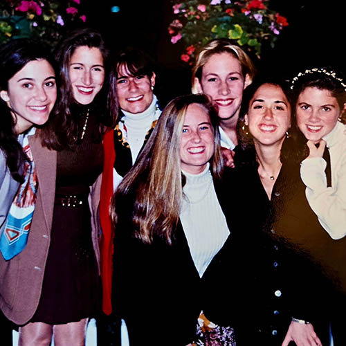 Seven women in semi formal outfits stand together
