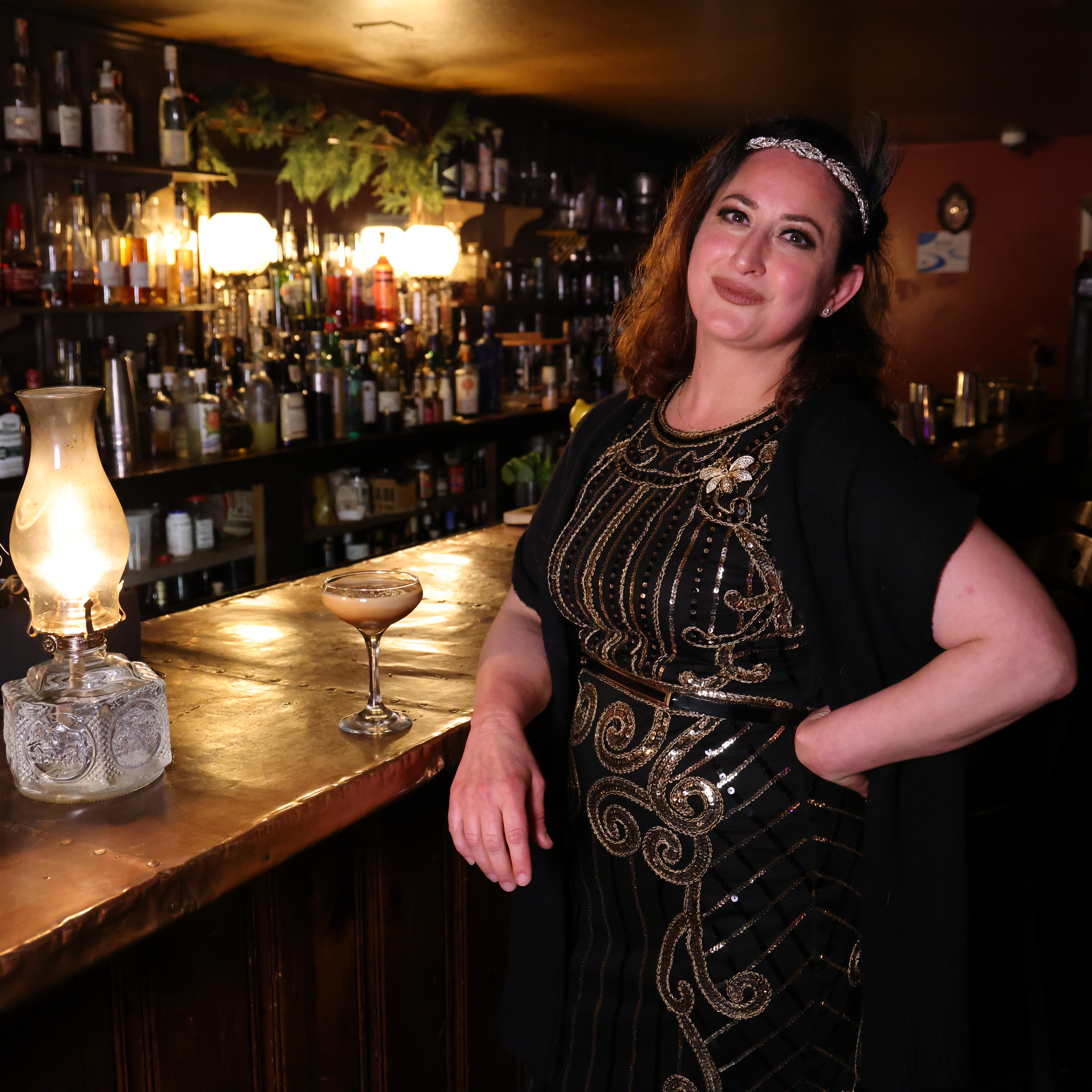 Linda Barsik '13G, co-owner of the Bookstore Speakeasy, poses at the bar 