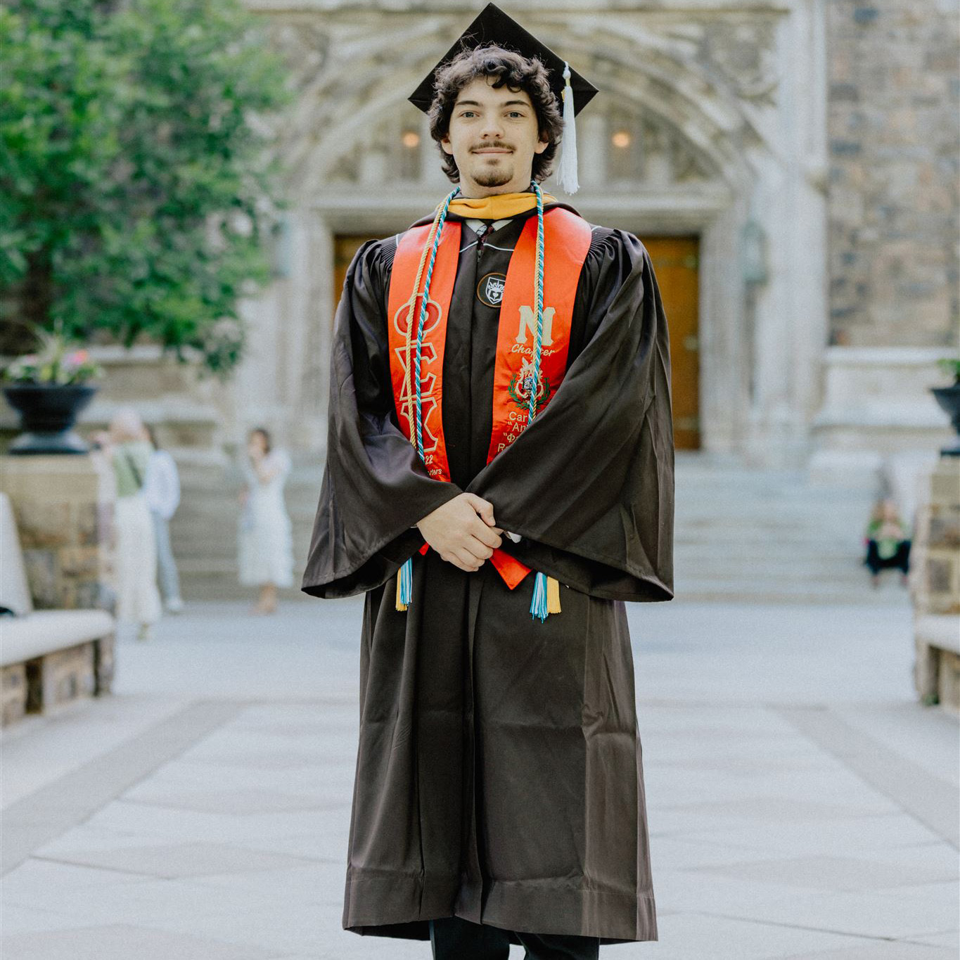Carson smiles in his Lehigh graduation cap, gown, stole, and cord.