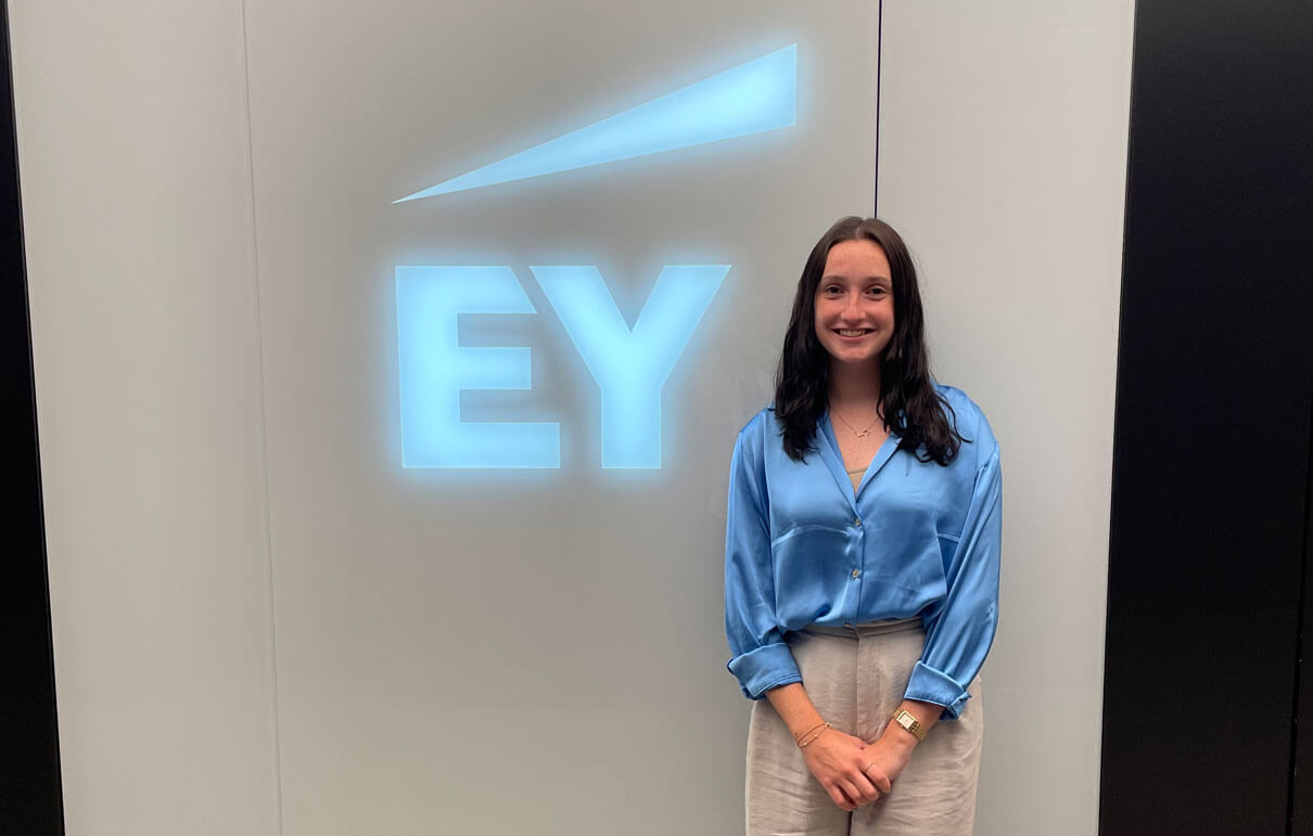 Casey Gannon posing next to the Ernst and Young logo