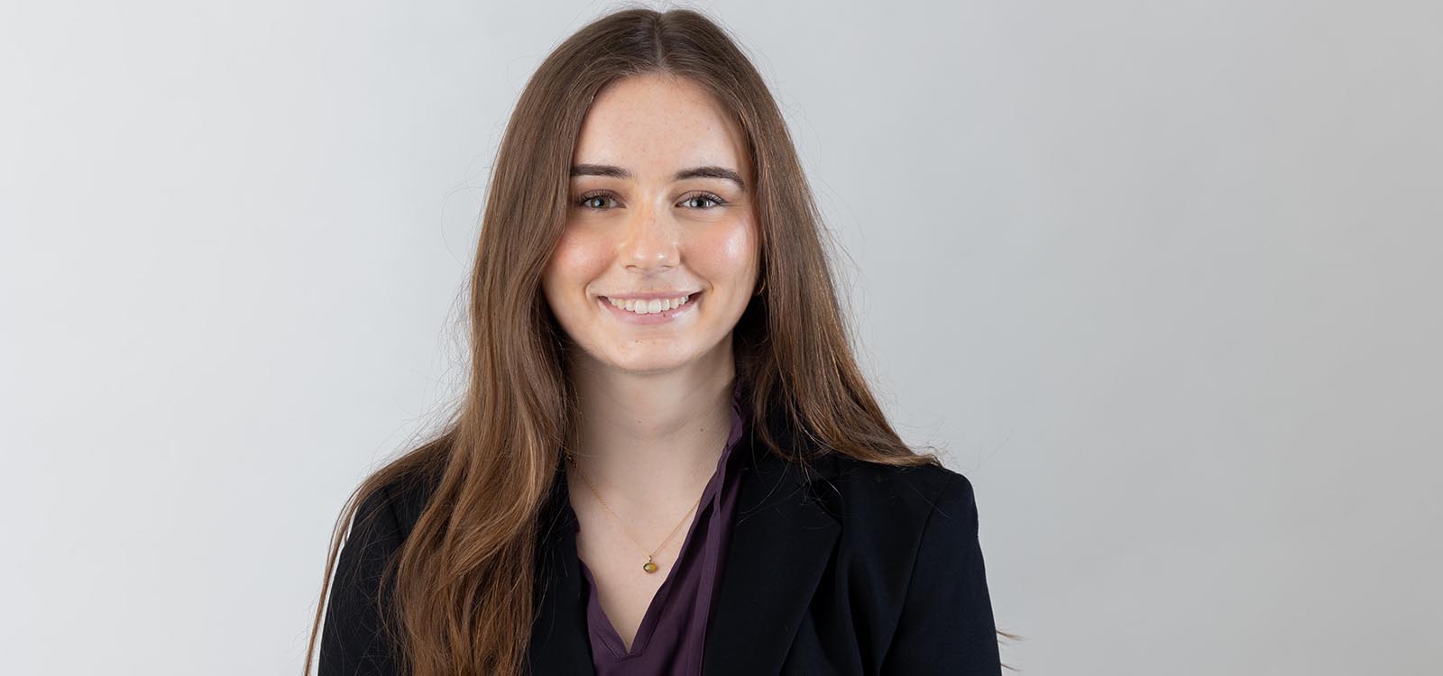 Catherine Adams wears a black blazer and purple shirt