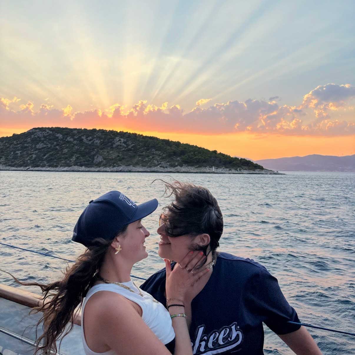Two women press their noses together for a photo before a beautiful sunset.