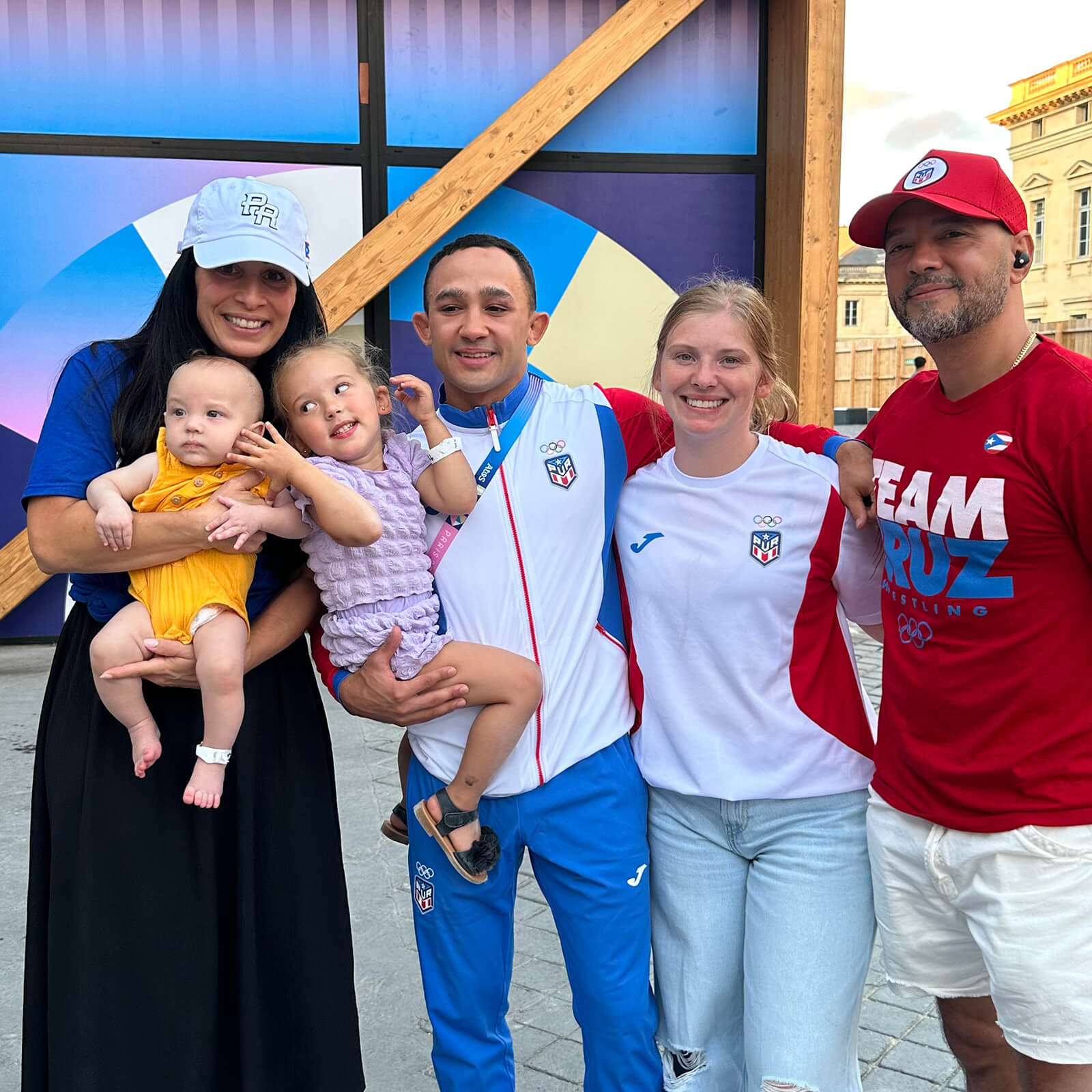 Darian poses with his family and friends outside in Paris, wearing Olympic gear.