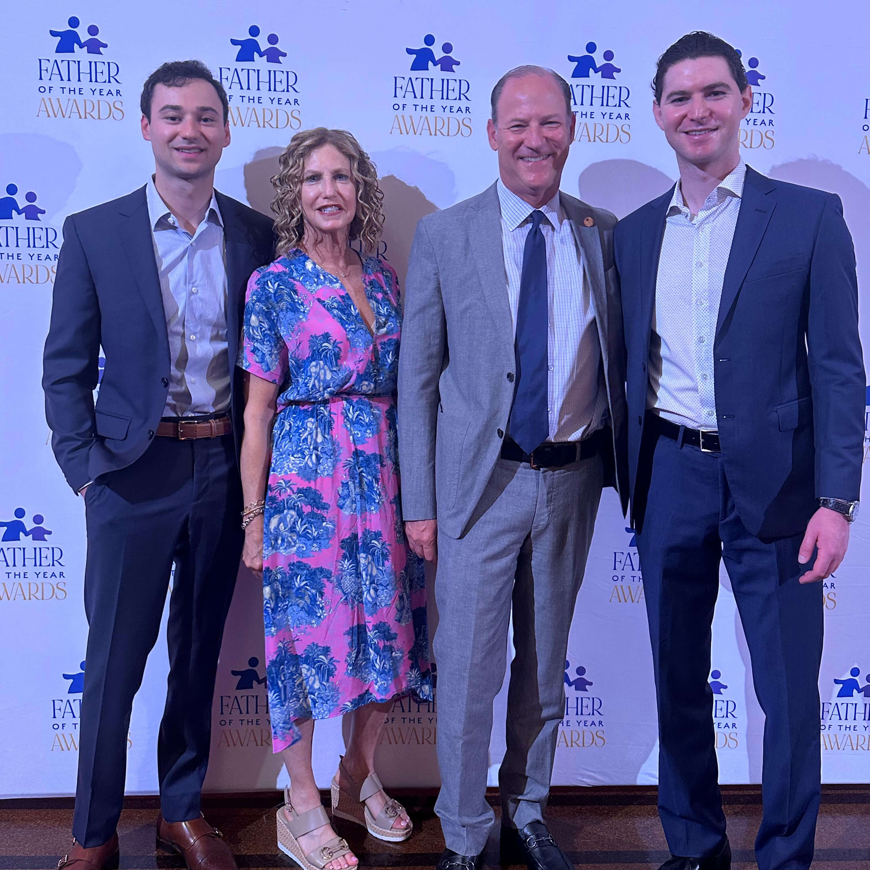 David, his wife, and his two sons pose in business casual at the Father of the Year awards.