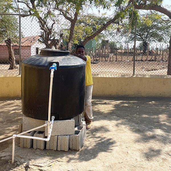 Boy leans on water tank