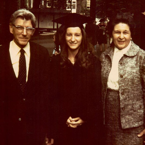 Emily Winn-Deen '74 in a cap and grown with her parents on either side