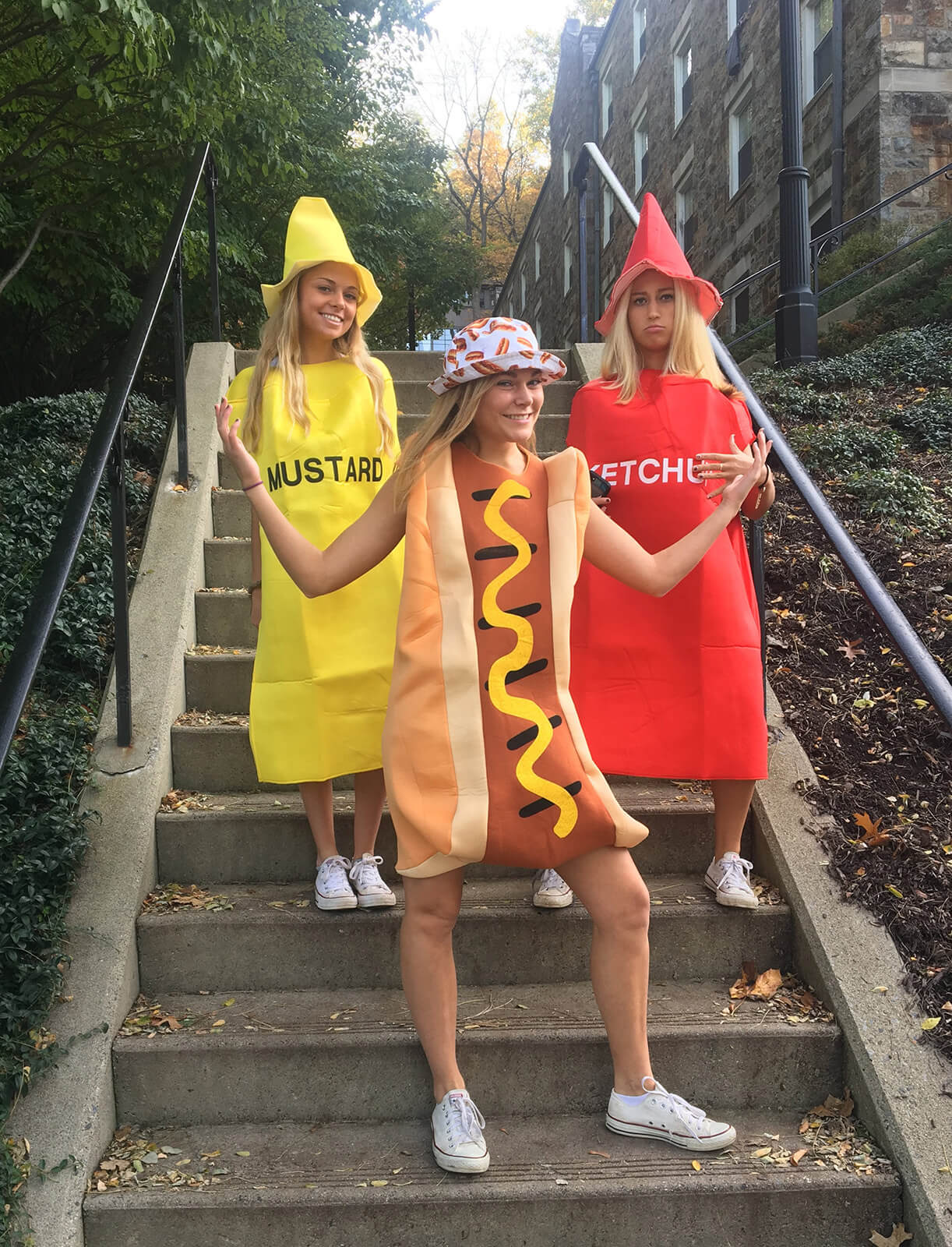 Posing on a flight of stairs on Lehgih’s campus, three college aged women are dressed in costumes: one as mustard, one as ketchup, and one as a hotdog.