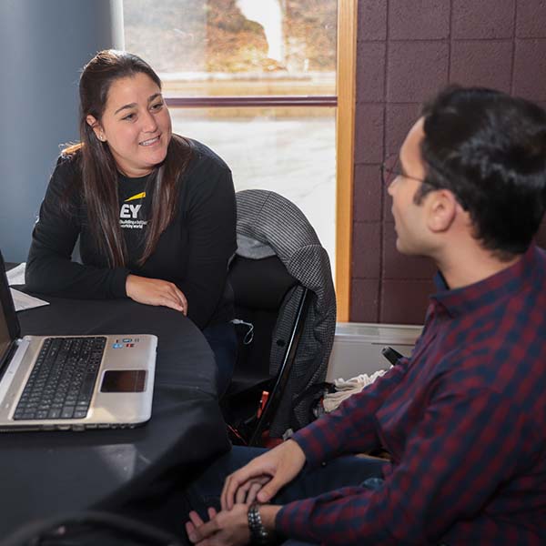 Alumna helps student at table