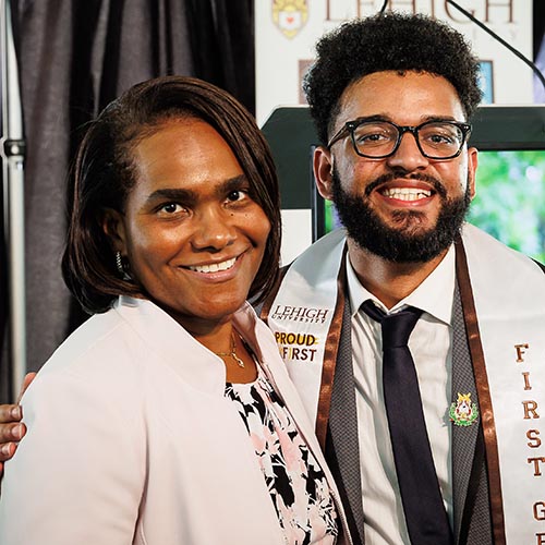 Ginelle Julien and Luis Caceres stand next to one another on stage at the event