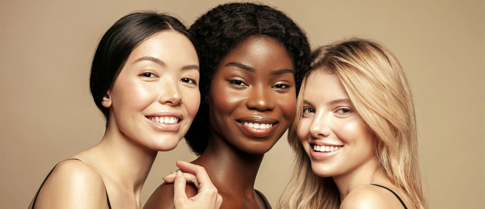 Three racially diverse women with different hair textures smiling