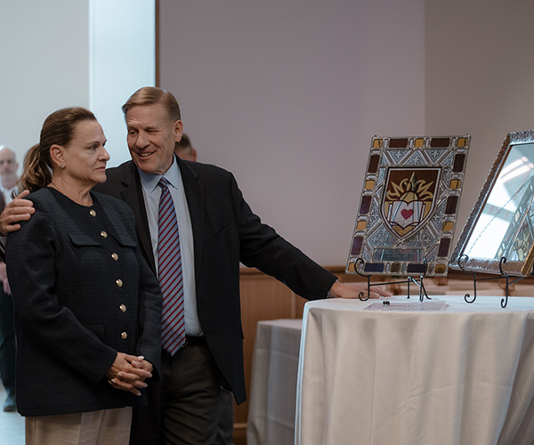 Kevin Clayton puts his arm around his wife Lisa and smiles as they stand before gifts