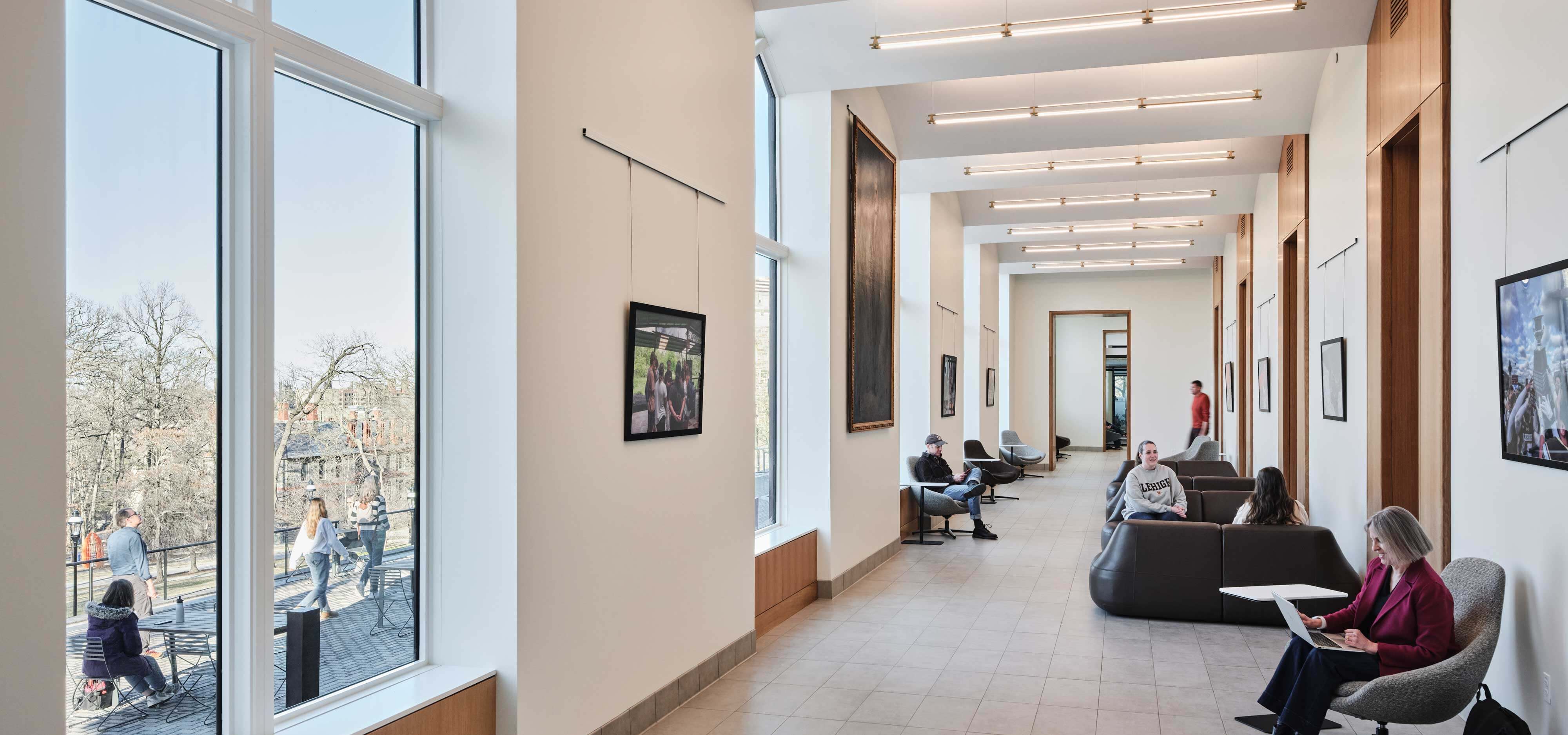 People sit on couches throughout the well lit Gallery.