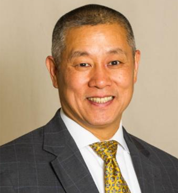 Gary Pan in a gray suit with yellow tie.