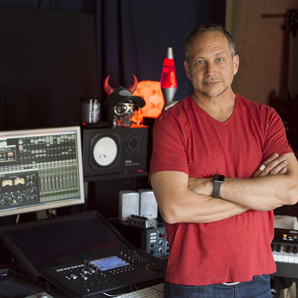 Jon stands at his mixing board