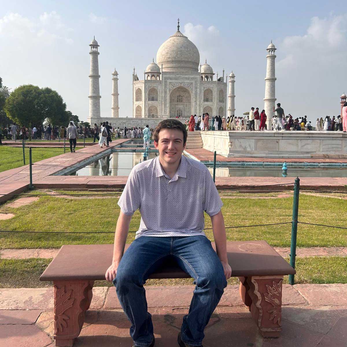 Hans sits on a bench near the Taj Mahal in Agra on a bright summer day.