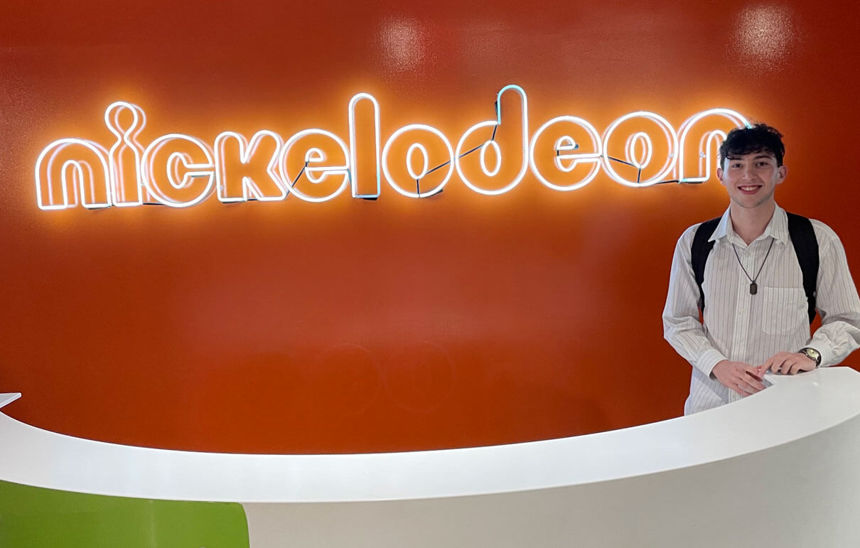 Harry Shmerler posing with the Nickelodeon logo