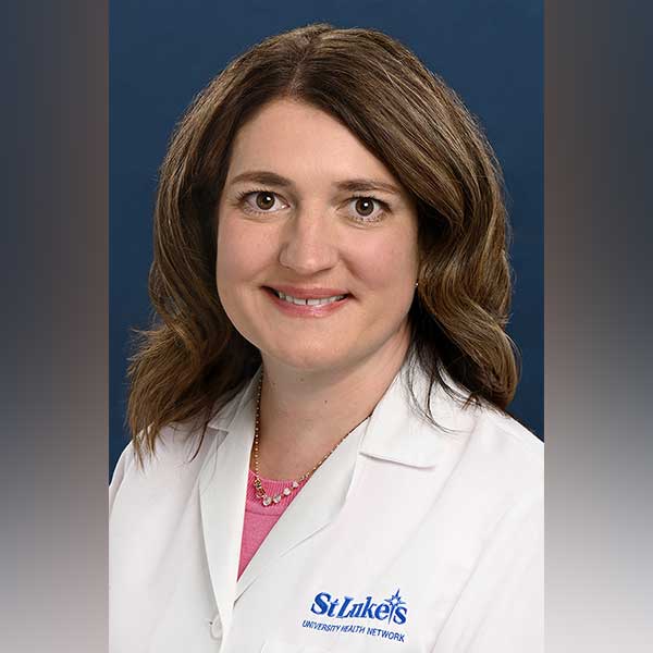 Holli smiles while wearing her St. Luke's white coat. 