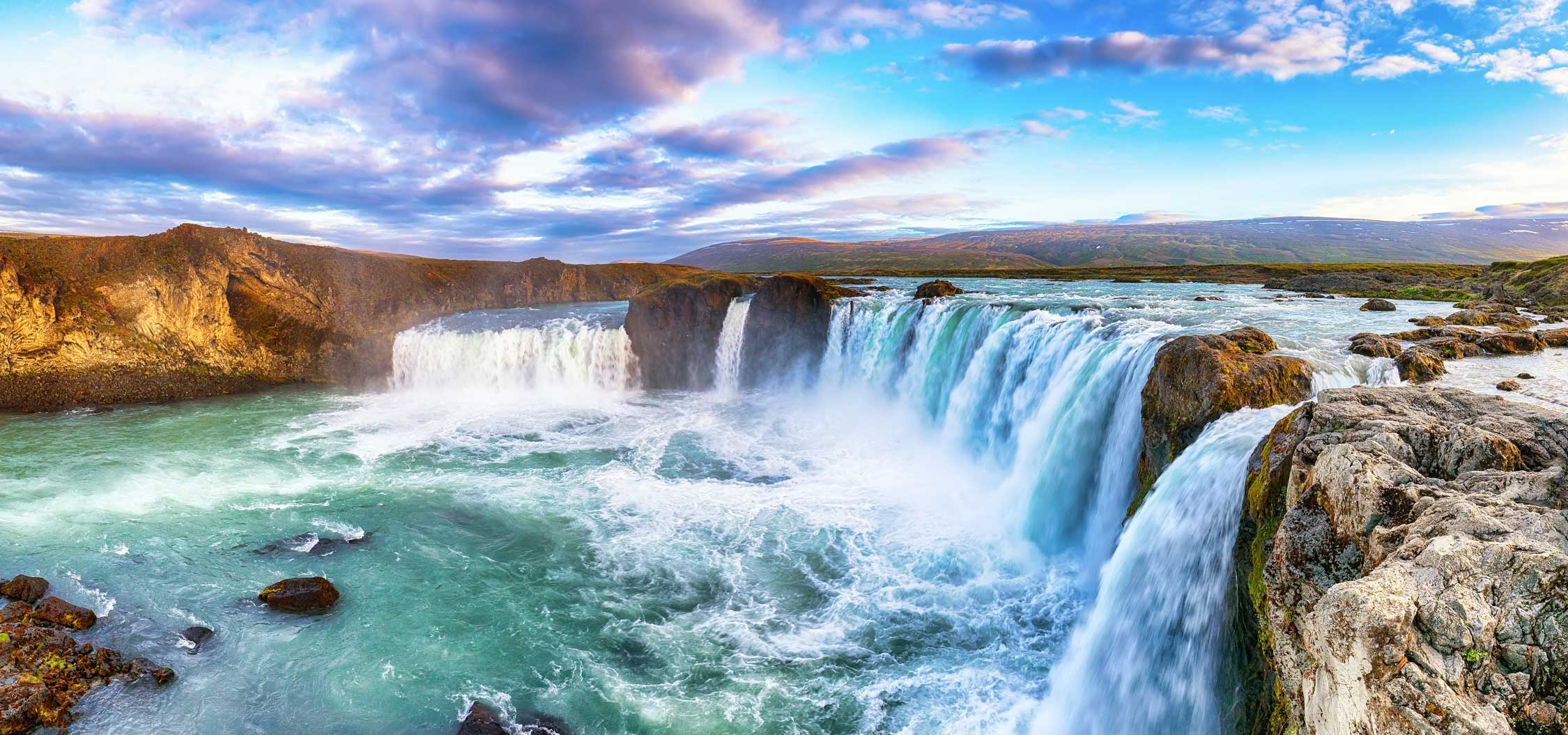 Godafoss Waterfall backed by a beautiful blue sky.