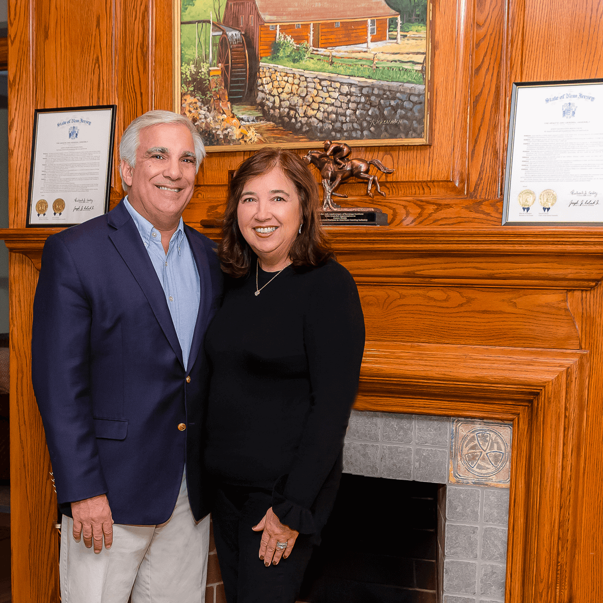 James and Sharon Maida standing together in front of a fireplace