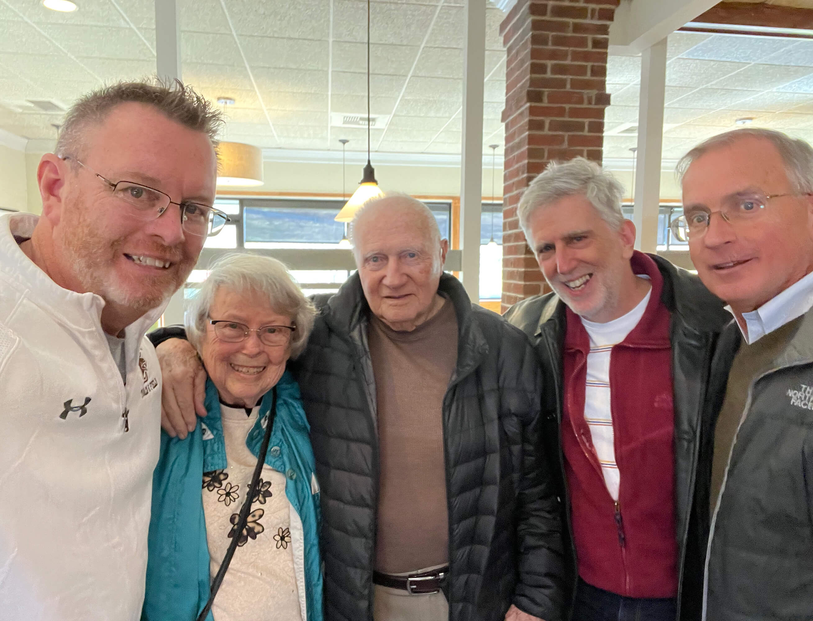 Jim Davis ’79, Lehigh University alumnus and former Colgate-Palmolive executive, and two other men pose for a selfie with Coach Covert and his wife, all wearing casual clothing and jackets. 