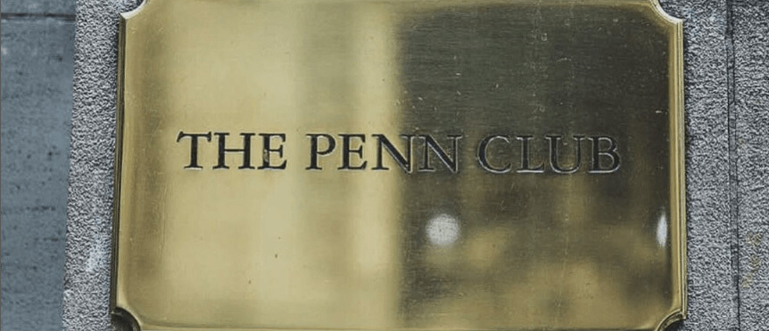 Brass sign reading “The Penn Club” mounted on a stone wall.