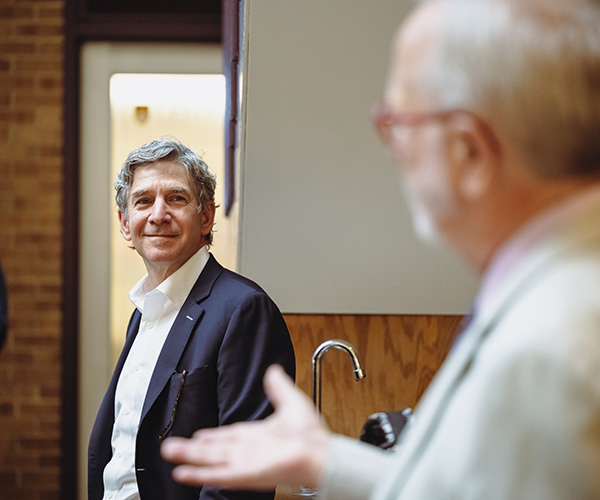 Jon Ballis smiles as he listens to Prof. Rick Matthews speak