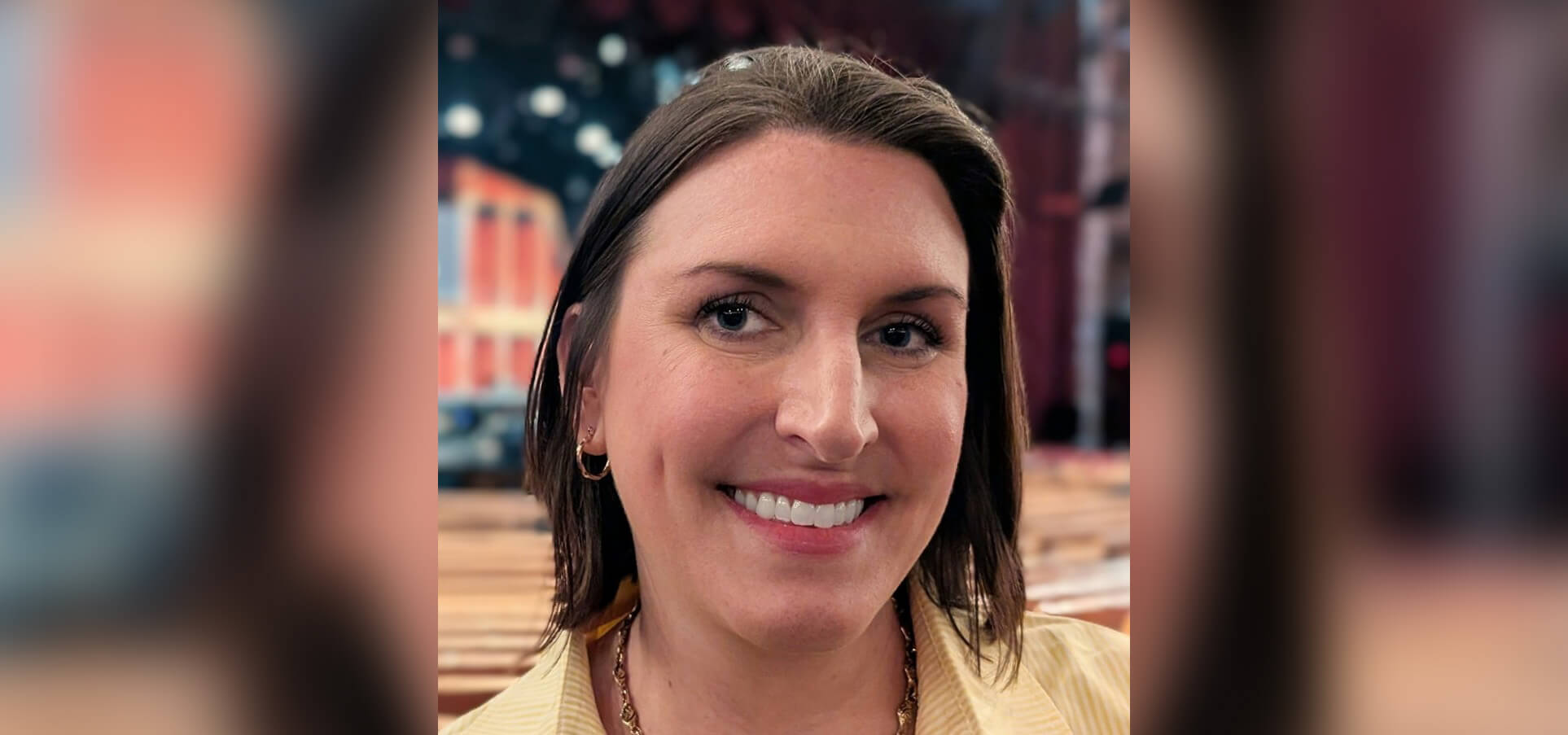 A woman with short brown hair smiles at the camera.