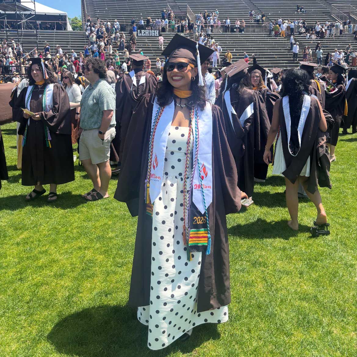 Kendalin wears her cap and gown over a white polka dot dress at graduation.