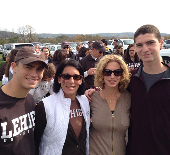 Kyle stands with her best friend and their sons at Family Weekend.